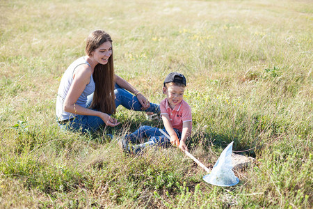 母亲和年幼的儿子在田野里捉蝴蝶图片