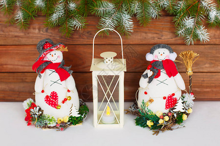 圣诞快乐新年贺卡与雪人和木制背景上的蜡烛灯站在冬天的雪人玩具问候图片