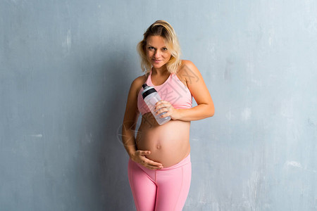 金发孕妇用瓶水打运图片