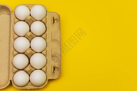 黄色背景纸箱中的鸡蛋图片