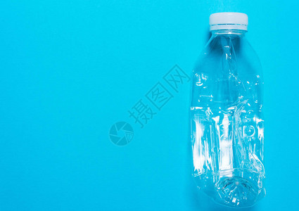 蓝色背景上的透明塑料瓶聚乙烯家庭垃圾分类的概念环图片