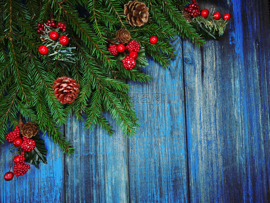 圣诞背景和装饰用冷杉树枝花环灯在旧木板上图片