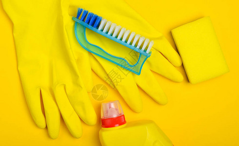 黄色背景的清洁设备Latex手套刷子海绵洗涤器瓶图片