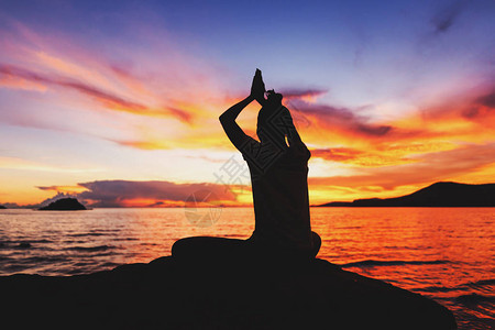 海边岩石上的女瑜伽图片