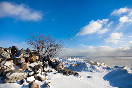 美丽的冬季景观与海景冬季上的石头图片