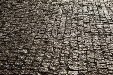 铺有斑岩立方体的城市鹅卵石的质地一条街道的地板与石瓦片花岗岩鹅背景图片