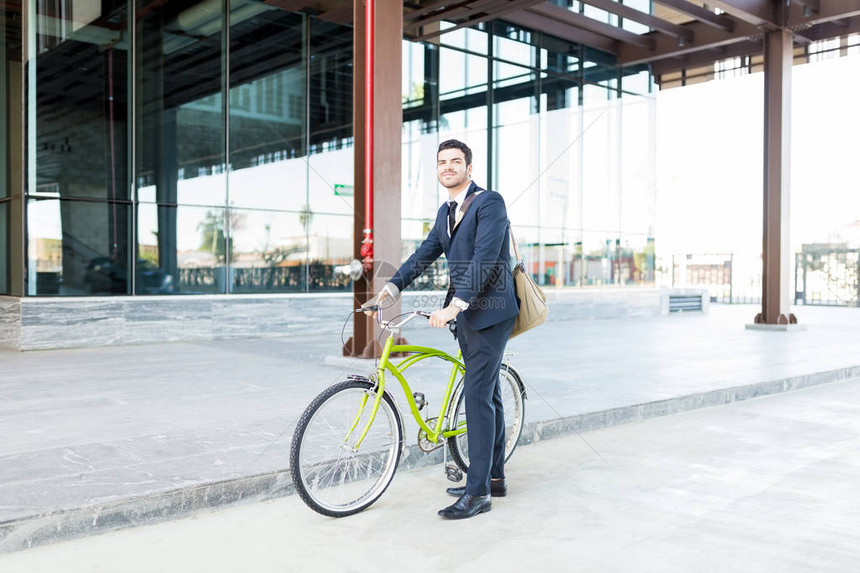 生态友好型商人与自行车站在城市图片
