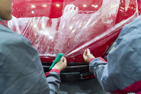 工人用抹刀安装汽车漆面保护膜背景