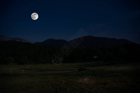 满月之夜穿过森林的山地路黑暗蓝天和月背景图片