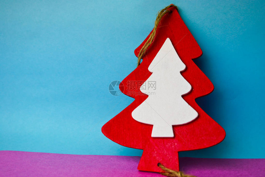 节日新年的圣诞节美丽明亮的多色快乐蓝色粉红色背景与小玩具木制自红白可爱圣诞树图片