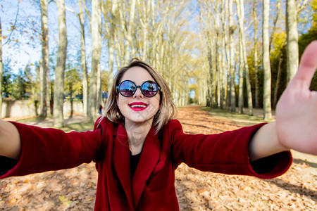 在法国凡尔赛秋季公园的太阳镜和大衣上快乐图片