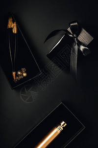 黑色瓶装香水和装饰羽毛的顶部视图图片