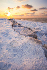 雪下沙滩和寒冷的海面日落时冰覆盖的海面图片