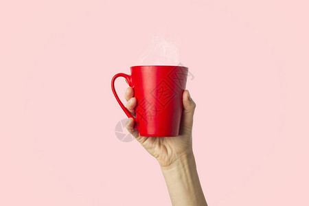 女手握着红杯和热咖啡或茶图片