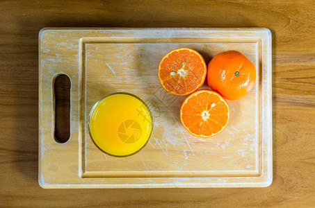在木块和木桌上用刀切开的橙子图片