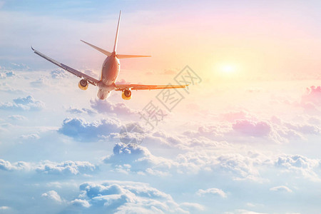 飞机在景色的日落时间飞越美丽的飞云图片