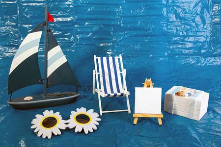 夏季度假概念玩具船和甲椅用蓝色底图片