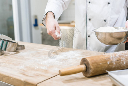 厨师手在木桌上撒面粉的剪影背景图片