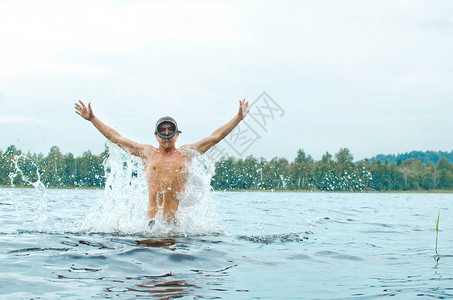 穿着潜水面具的男人跳出水面喷洒图片