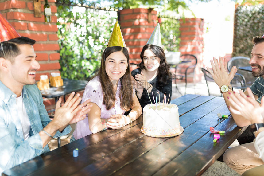年轻朋友在户外餐厅为有生日蛋糕的女图片