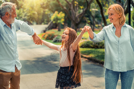 快乐的幸福家庭在夏天在公园路上走在一起家人和睦相处的概念图片