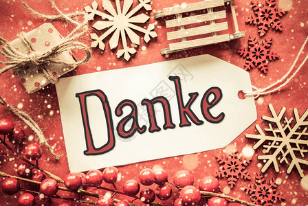 标签与德国书法Danke意味着谢平躺着明亮的红色圣诞装饰图片