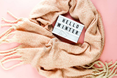 温暖舒适的冬装粉色围巾灯箱作为柔和粉色背景的框架图片