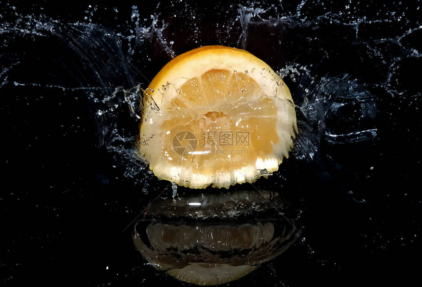 柠檬掉进水里溅起水花黑色背景图片