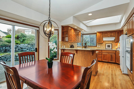 美国房子的厨房室内配有樱桃木餐桌和大房背景图片