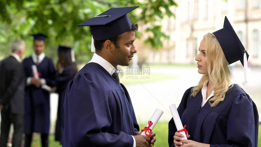 穿着学术礼服和帽子并有毕业证书的人图片
