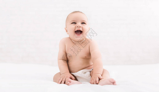 6个月的婴儿坐在床上笑时图片