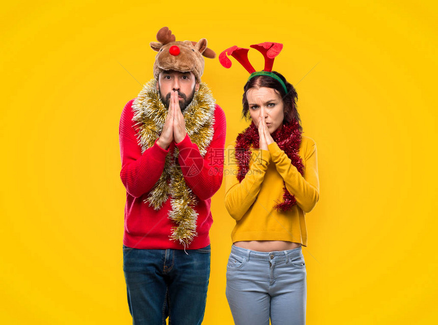 为圣诞节日打扮的一对情侣保持棕榈在一起人们要的是黄色背图片