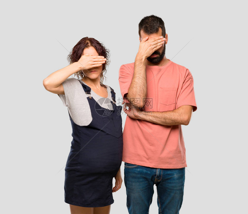 与孕妇一起亲手遮住眼睛不要在孤立的灰色背景上看到一图片