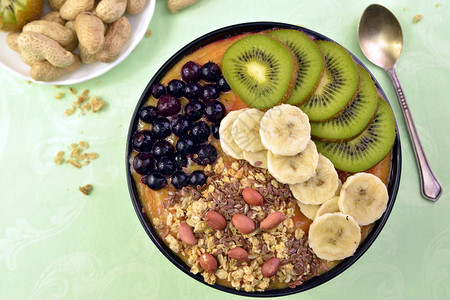 早餐有穆埃斯利阿凯蓝莓冰沙和基维香蕉绿底水果图片