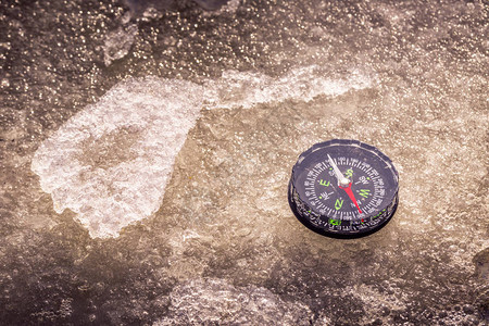 指南针在寒冷的冬天躺在冰面图片
