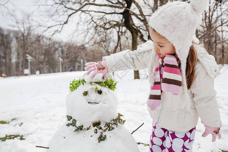 孩子在冬日在公园里堆雪人图片