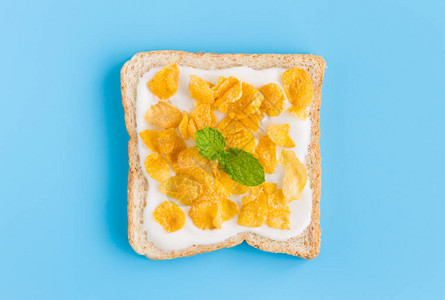 玉米片上酸奶面包和薄荷蓝色粉彩背景平面缩放谷物早餐面包健康清洁食品图片