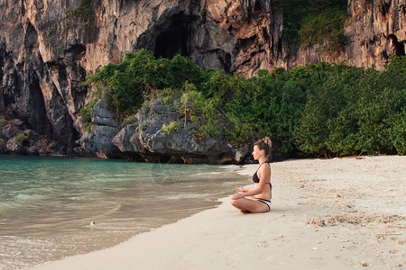 妇女练习瑜伽和冥想在沙滩图片