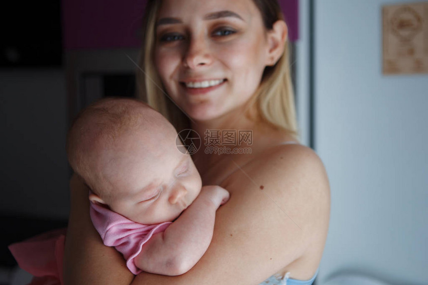 年轻漂亮的女人妈抱着她两个月大的女儿微笑着孕产妇保健母乳喂养和幸图片