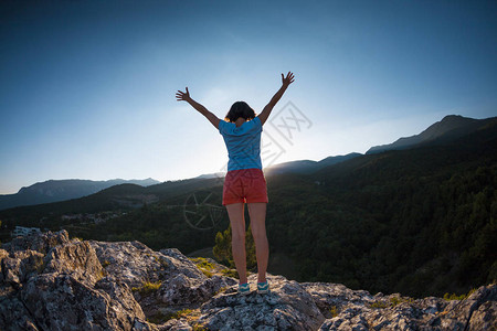 山顶的少女举起双手图片