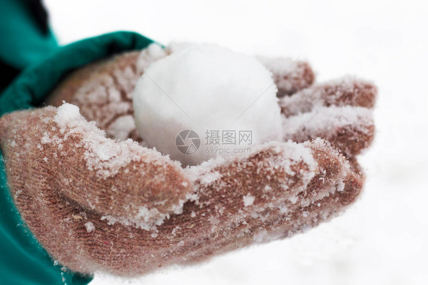 穿手套的女孩拿着雪球在图片