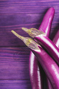 紫色背景的长茄子顶视图背景图片