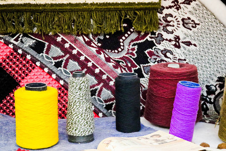 多彩亮丽的纱线人造丙烯酸纤维线缝纫线卷轴在亮色织物的背景下制作衣图片