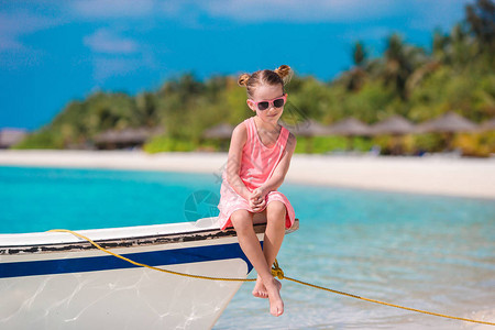 快乐的小女孩在沙滩上渡暑假图片