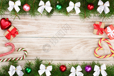 圣诞框架由装饰球弓甘蔗和盒子的木质圆形树枝组成图片