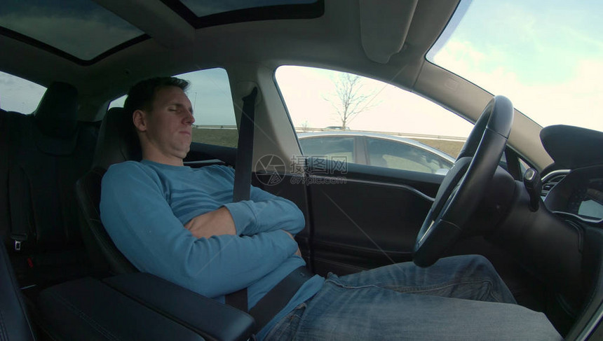 当他的高科技自动驾驶汽车在高速公路上的高峰时段行驶时图片