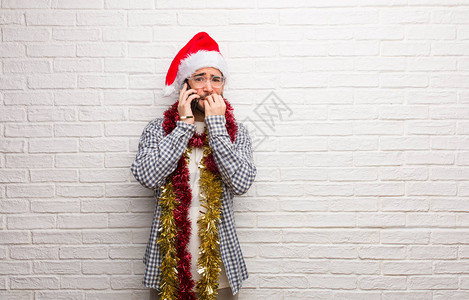 年轻人坐着礼物庆祝圣诞节咬指甲紧图片