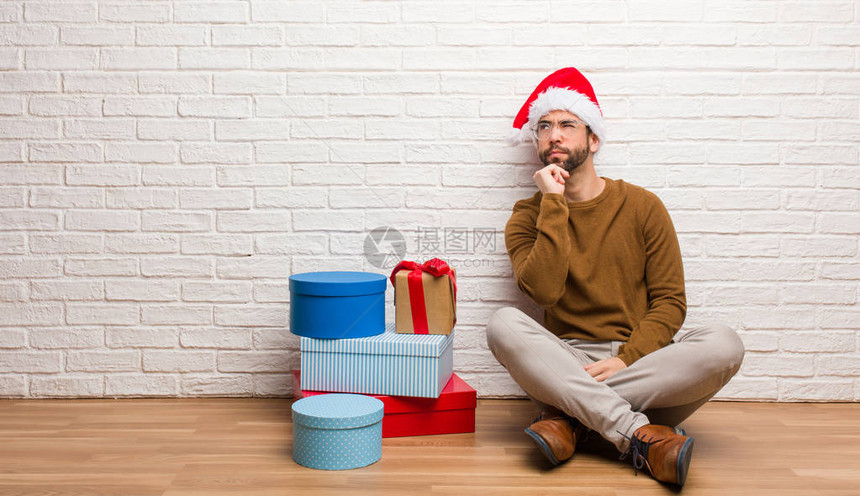 年轻人坐着礼物庆祝圣诞节的喜悦图片