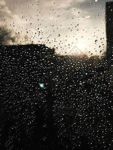 玻璃上的雨滴和太阳光线的美丽图像图片