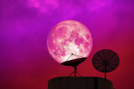 粉红色月亮后环月光卫星圆盘夜空中红云背景图片